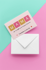 postcard encima de sobre blanco con fondo azul y rosa. tarjeta con frase "mama ser tu hijo es mi trauma favorito"